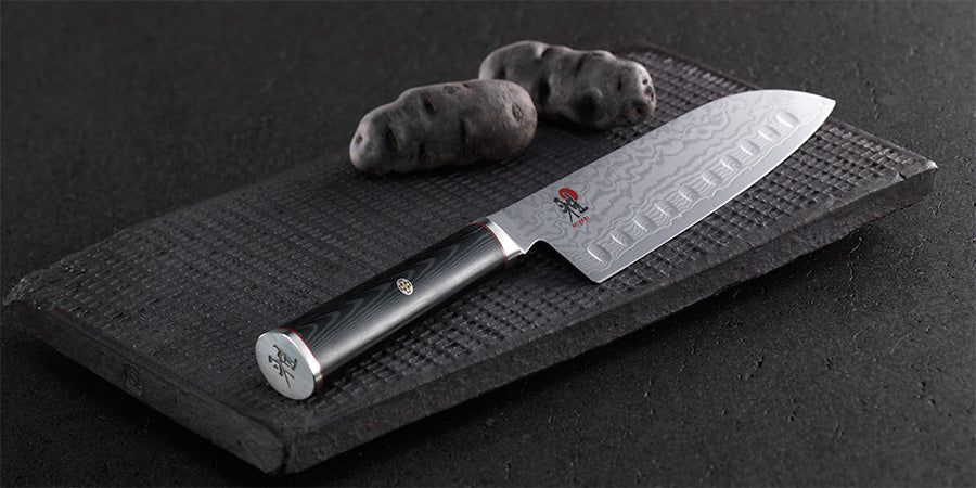 MIYABI-5000FCT Santoku liggende på en svart fjøl - Me & Max AS